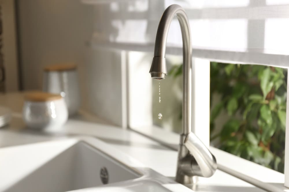 Droplets of water trickling down a tap