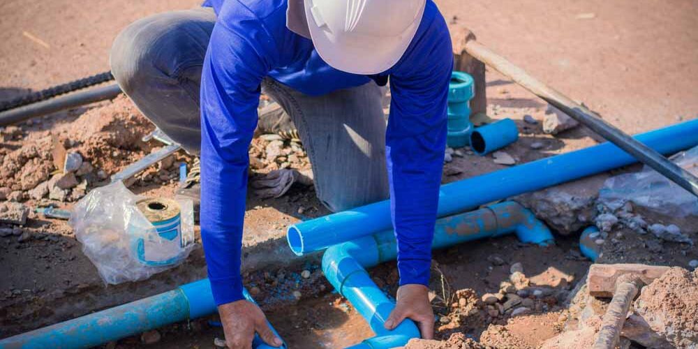 Plumber working on a busted pipe line Plumber working on a busted pipe line